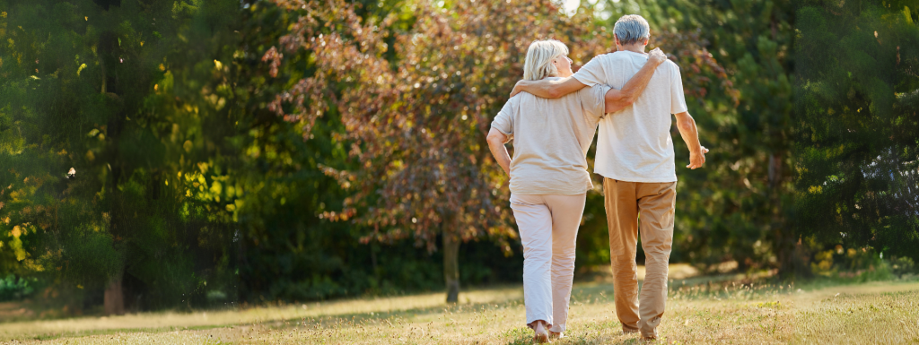 Older couple walking together in the grass